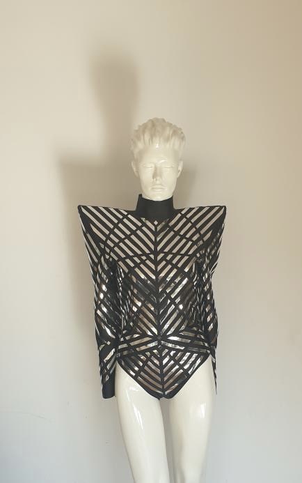 Futurystyczne body z czarno-srebrnych lustrzanych pasów na białym manekinie – projekt Sensual Woman, kostium Elki, konstrukcja geometryczna.