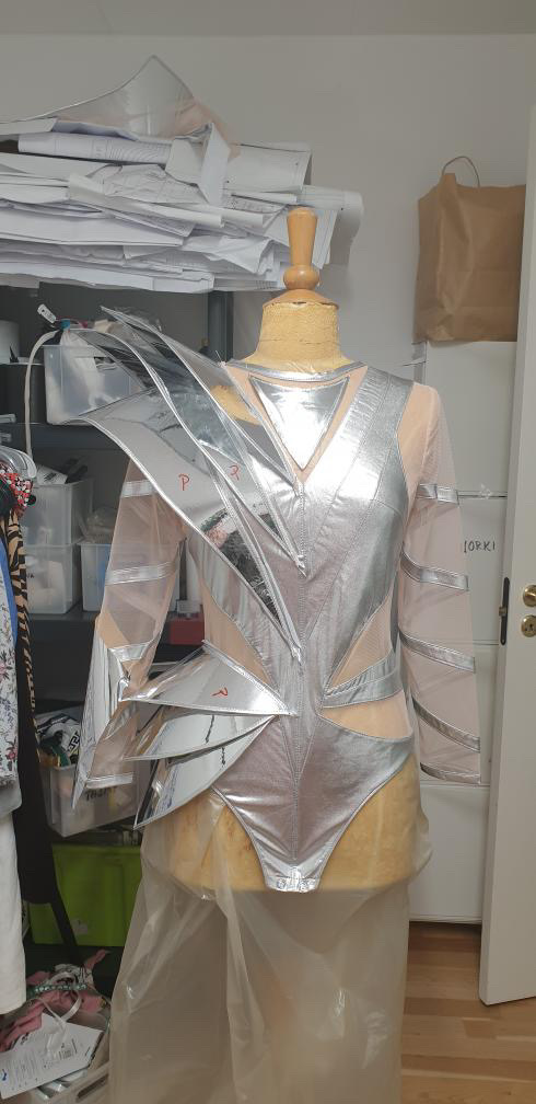 Back view of silver futuristic armor bodysuit on mannequin, detailed avant-garde fashion construction .Projekt zbroi na manekinie