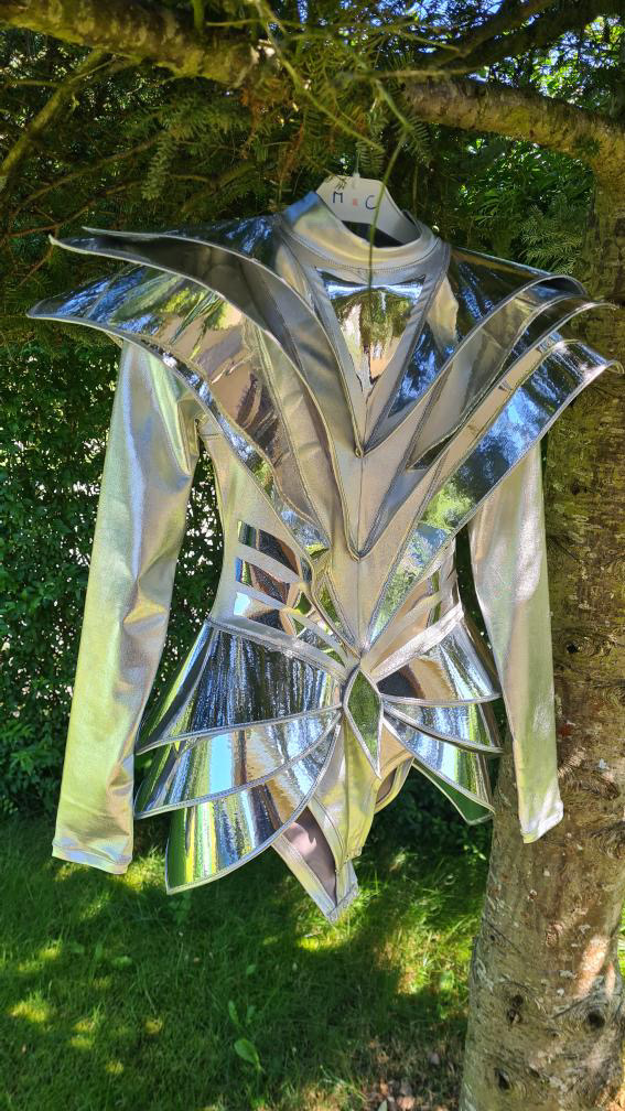 Front view of futuristic silver armor bodysuit photographed outdoors, visionary costume design with geometric structure