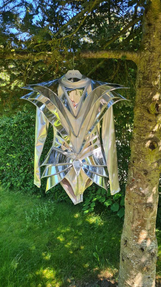 Avant-garde silver armor bodysuit shown in full body view outdoors, futuristic stage costume design