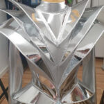 Detail of futuristic armor bodysuit shoulder structure, sculptural metallic avant-garde design