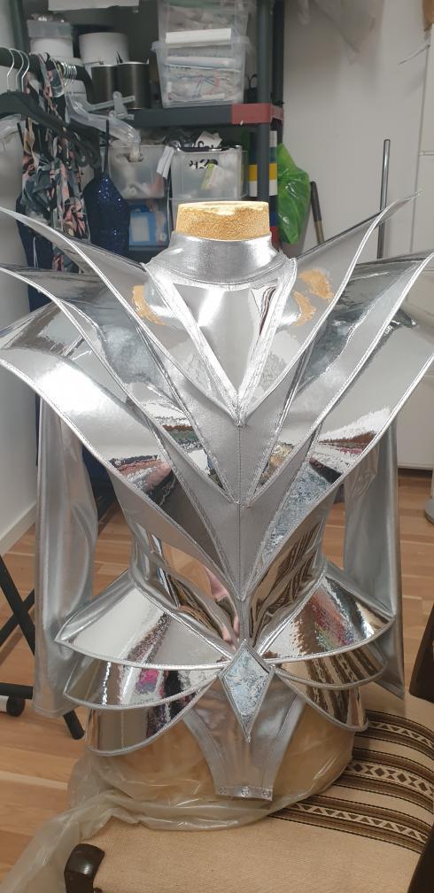 Detail of futuristic armor bodysuit shoulder structure, sculptural metallic avant-garde design