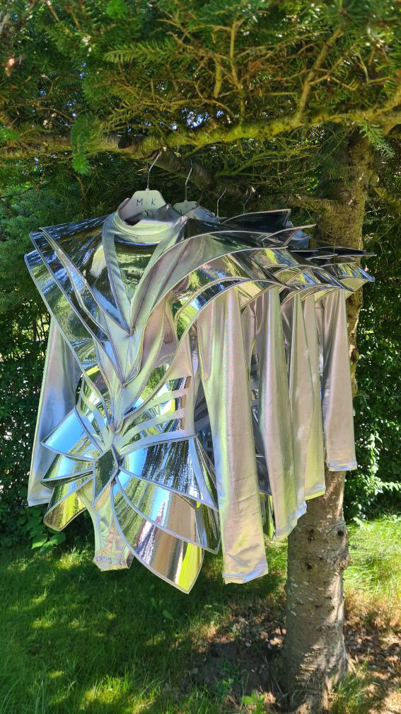 Avant-garde silver armor bodysuit shown in full body view outdoors, futuristic stage costume design