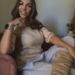 Uśmiechnięta kobieta prezentująca dopasowaną bluzkę ecru, stylizacja boho chic