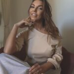 Kobieca stylizacja z bluzką ecru z opadającym ramieniem, dopasowany krój slim fit