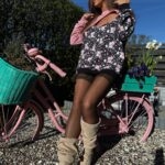 modelka w bluzie rose pozująca na rowerze