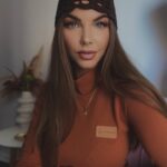 Kobieta w dopasowanym cynamonowym golfie z miękkiej dzianiny ze stójką i naszywką Sensual Woman w jesiennej stylizacji.